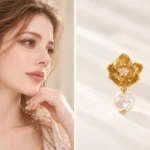 gold flower pearl drop earrings lifestyle and front view